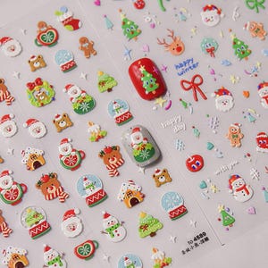 May include: A sheet of Christmas-themed nail stickers with various designs, including Santa Claus, snowmen, reindeer, gingerbread men, snow globes, and Christmas trees. The stickers are in red, green, white, and brown colors. The sheet also includes the text "happy winter", "happy day", and "with you".