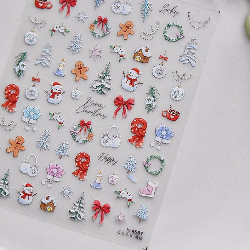 May include: A sheet of clear sticker paper with a variety of Christmas-themed stickers. The stickers feature images of snowmen, gingerbread men, presents, wreaths, and other holiday decorations. The stickers are in a variety of colors, including red, green, white, and blue.