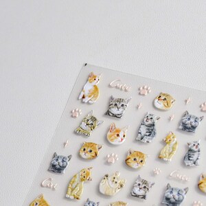 May include: A sheet of clear sticker paper with a variety of cute cat stickers. The stickers feature different colored cats with different expressions. The stickers are perfect for adding a touch of whimsy to your planner, journal, or laptop.