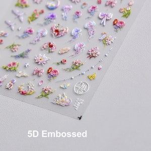 May include: A sheet of 5D embossed nail stickers with a variety of designs, including flowers, butterflies, jellyfish, and stars. The stickers are on a clear background and are ready to be applied to nails.