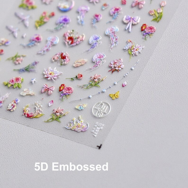 May include: A sheet of 5D embossed nail stickers with a variety of designs, including flowers, butterflies, jellyfish, and stars. The stickers are on a clear background and are ready to be applied to nails.