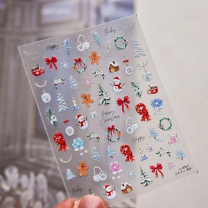 May include: A sheet of clear nail stickers with a variety of Christmas-themed designs, including snowmen, gingerbread men, wreaths, and presents. The stickers are printed with the words "Happy", "Lucky", and "Merry Christmas".