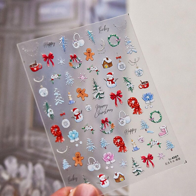 May include: A sheet of clear nail stickers with a variety of Christmas-themed designs, including snowmen, gingerbread men, wreaths, and presents. The stickers are printed with the words "Happy", "Lucky", and "Merry Christmas".