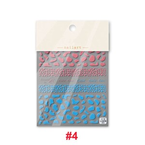 Op de afbeelding: Een pakje nagelkunst stickers met een koe-print ontwerp. De stickers zijn roze, blauw en grijs. Het pakje is gelabeld met het nummer "#4".