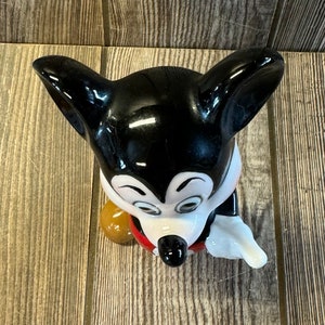 以下が含まれることがあります： ミッキーマウスの白黒のセラミック製フィギュア。ミッキーは赤いショートパンツと白い手袋を着ています。彼は右手に茶色のボールを持っています。