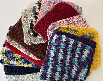 May include: A stack of colorful crocheted dishcloths in various patterns and colors, including purple, blue, yellow, red, brown, and white.
