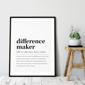Op de afbeelding: Zwart-witte printbare wandkunst met de definitie van het woord "difference maker". De definitie luidt: "Iemand die een groot verschil kan maken in de wereld met slechts een paar woorden of daden. Een enthousiaste persoon die zich toelegt op het verbeteren van het leven van anderen en de kracht heeft om anderen te inspireren en te mobiliseren om positieve veranderingen teweeg te brengen."