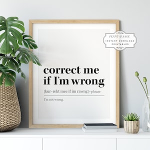 May include: A printable wall art design with a black and white typography quote that reads "correct me if I'm wrong [kur-rekt mee if im rawng] phrase I'm not wrong." The design is framed in a light wood frame and is sitting on a white surface.