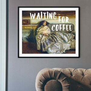 Op de afbeelding: Een ingelijste print van een schilderij van een vrouw die op een bank ligt. De tekst "WAITING FOR COFFEE" is in witte letters op een zwarte achtergrond geschreven.