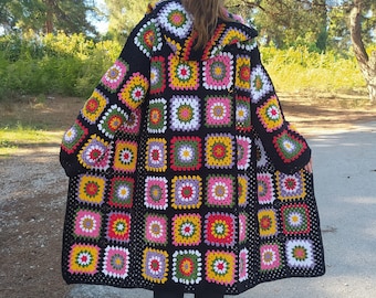 May include: A black crochet cardigan with a colorful granny square pattern. The cardigan has a hood and is shown in size XXLarge 45 inches.