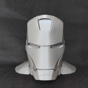 May include: A 3D printed, gray, Iron Man helmet bust. The helmet has a detailed design with a textured surface.