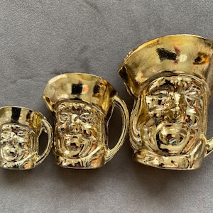 Set of three Brass colour Toby Jugs (129)