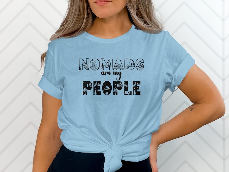 Light blue t-shirt with "NOMADS ARE MY PEOPLE" text and camping graphics.