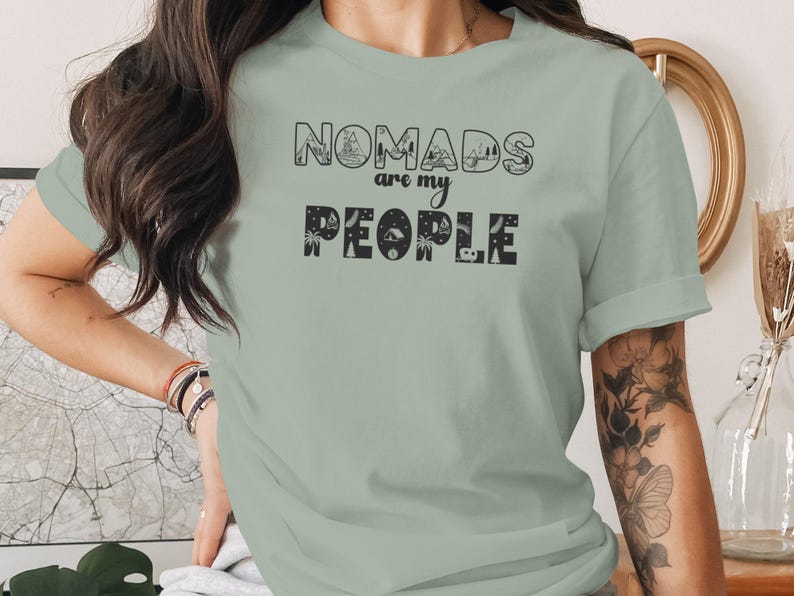 Green t-shirt with "Nomads are my People" text and travel icons.