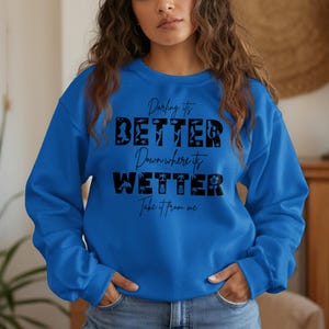 Blue sweatshirt with "Darling it's better down where it's wetter" text.
