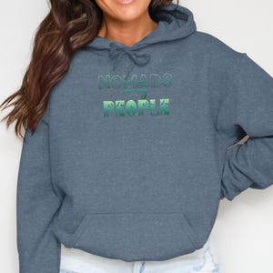 Blue hooded sweatshirt with "NOMADS ARE MY PEOPLE" text.