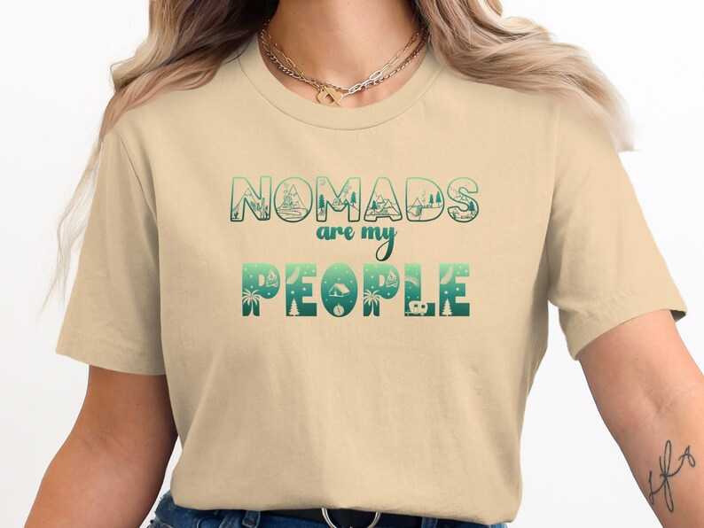 Cream t-shirt with "Nomads are my people" text and outdoor scene graphics.