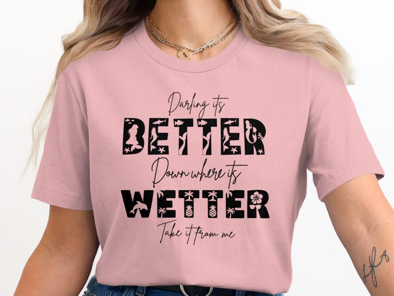 Pink t-shirt with "Darling its BETTER Down where its WETTER Take it from me" in black lettering.