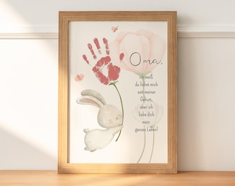 May include: A framed print with a pink flower and a white bunny. The print has a handprint in red paint and the text "Oma, ich weiß du liebst mich seit meiner Geburt, aber ich liebe dich mein ganzes Leben!"