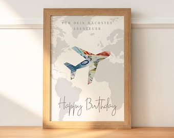 May include: A framed print with a world map background and a paper airplane made of money. The text "For your next adventure" and "Happy Birthday" is printed on the print.