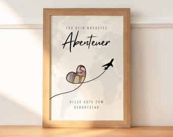 May include: A framed print with a world map background and a heart-shaped design filled with money. The text "For your next adventure" and "All the best for your birthday" is printed on the print.
