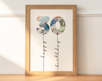 May include: A framed print featuring the number "30" in a balloon design, filled with images of currency. Below the numbers, the words "happy birthday" are written in a delicate script. The frame is made of light brown wood.