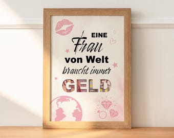May include: A framed print with a pink and white background. The text reads "Eine Frau von Welt braucht immer GELD". The word "GELD" is made of money bills.