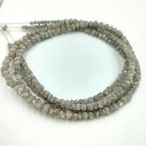 Può includere: Una collana di perline di diamante grezzo grigio. Le perline sono piccole e hanno un aspetto naturale e non lucidato.