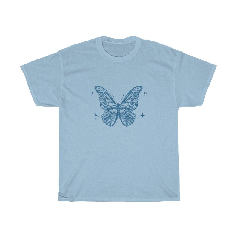 May include: A light blue t-shirt featuring a blue butterfly graphic and small stars on the front.