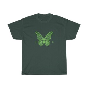 May include: A dark green t-shirt featuring a light green butterfly graphic. The butterfly has a detailed design and is surrounded by small stars.