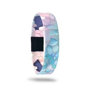 May include: A fitness tracker wristband with a mosaic pattern in shades of blue, pink, and purple. The band has a black clasp with the brand name. The overall design is modern and stylish.