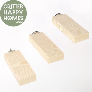 May include: Three natural wood platforms with a rounded edge and a metal screw attachment. The platforms are different sizes and are arranged in a staggered pattern.