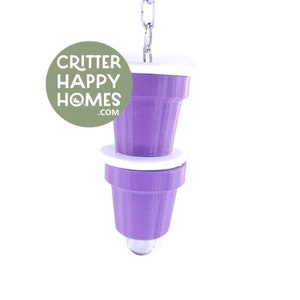 May include: Purple hanging bird toy with two cups and a white top. The toy is attached to a silver chain. The toy is labeled "Critter Happy Homes.com".