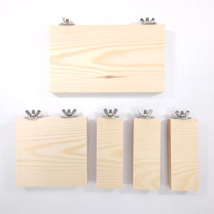 以下が含まれることがあります： 金属製のブラケットが付いた木製の棚が5つあります。棚はサイズが異なり、一列に並んでいます。棚は明るい色の木でできており、自然な仕上げになっています。