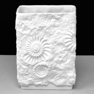 Puede incluir: Jarr&oacute;n rectangular blanco con una superficie texturizada similar a la piedra. El jarr&oacute;n presenta f&oacute;siles de amonitas en relieve. El dise&ntilde;o es de color neutro, adecuado para varios estilos de decoraci&oacute;n del hogar. Es un art&iacute;culo decorativo.