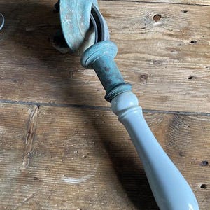 Könnte beinhalten: Ein antiker Türgriff mit Messingbasis und weißem Keramikgriff. Der Griff hat ein dekoratives Design und ist in gutem Zustand.