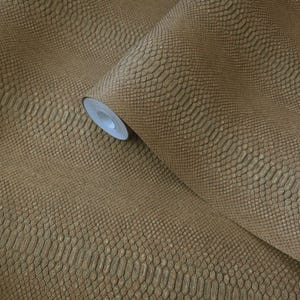 May include: A roll of textured wallpaper in a warm, earthy brown hue. The wallpaper features a detailed, embossed pattern resembling snakeskin. The roll is partially unrolled, revealing the white core.