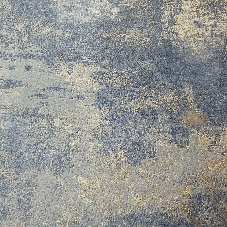 May include: A close-up of a textured surface with a blue and gold color scheme. The surface has a rough, uneven texture, with a subtle metallic sheen.