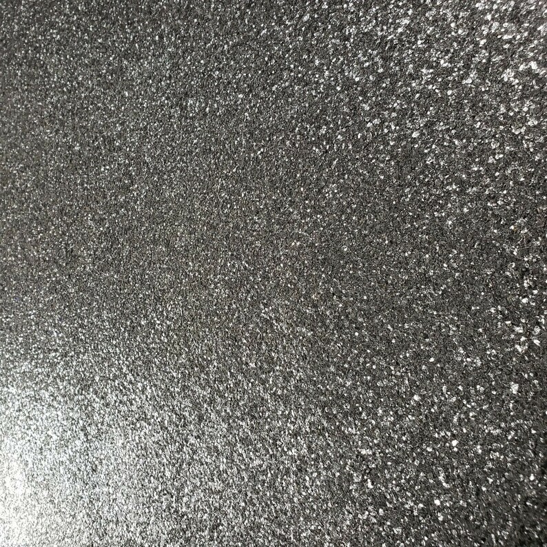 May include: A close-up of a textured, gray surface with a fine, sparkly finish.