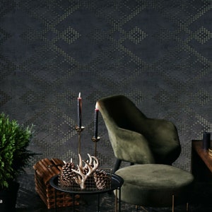 May include: A dark, patterned wallpaper forms the backdrop for a cozy living space. A green velvet armchair and ottoman sit near a small table with decorative items, including pine cones, antlers, and candles. A woven basket and potted plant add to the room's ambiance.