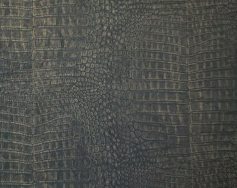 May include: Close-up of a dark gray textured fabric with a crocodile skin pattern. The fabric has a subtle sheen and a slightly raised texture.