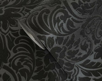 May include: Black damask wallpaper with a raised, textured pattern. The wallpaper has a subtle sheen and a classic, elegant design.