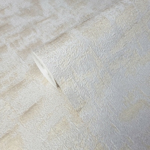 May include: A roll of textured wallpaper in a light beige color with a subtle shimmer.