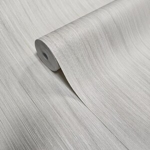 May include: A roll of white wallpaper with a subtle, textured, wood-grain pattern.