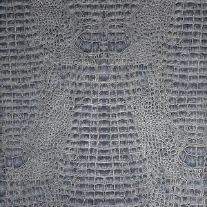 May include: A close-up of a dark gray textured fabric with a crocodile skin pattern.