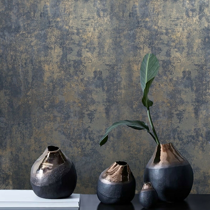 May include: Four black ceramic vases with a metallic gold glaze finish. The vases are arranged on a white surface in front of a textured blue and gold background.