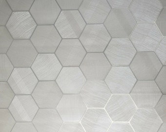 May include: A white wallpaper with a hexagonal pattern. The hexagons have a subtle textured design.