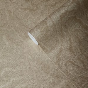May include: A roll of brown wallpaper with a subtle textured pattern. The wallpaper has a slightly metallic sheen.