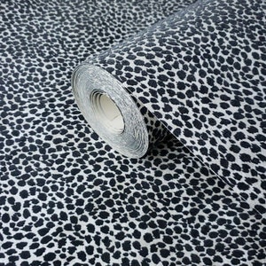 May include: A roll of white and black animal print wallpaper. The wallpaper has a textured, velvety finish.