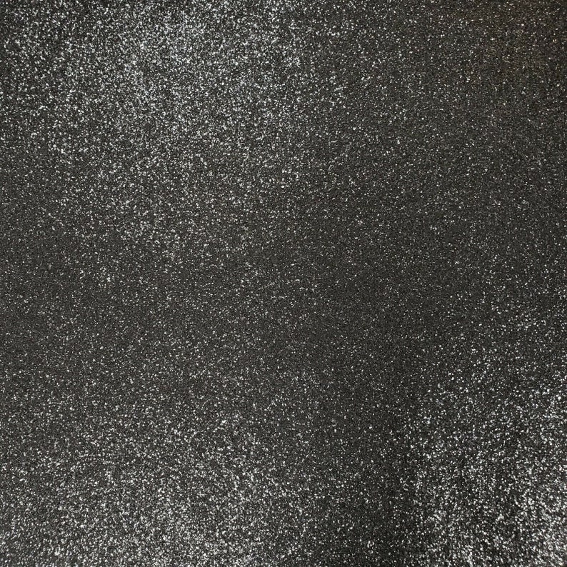 May include: A close-up of a black fabric with a sparkly, glittery texture.